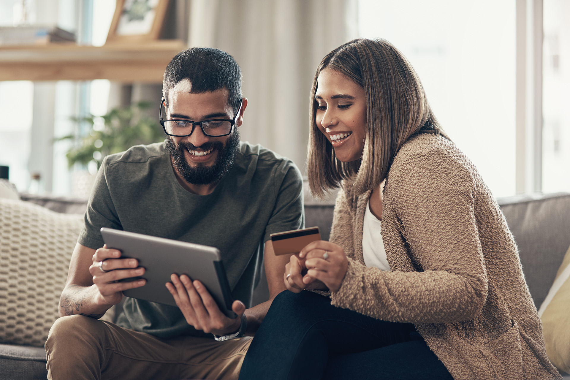 couple holding card and tablet