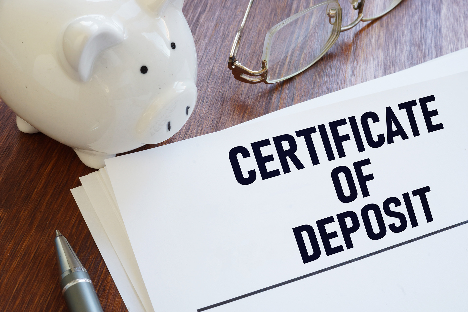piggy bank, glasses, and certificate of deposit letter